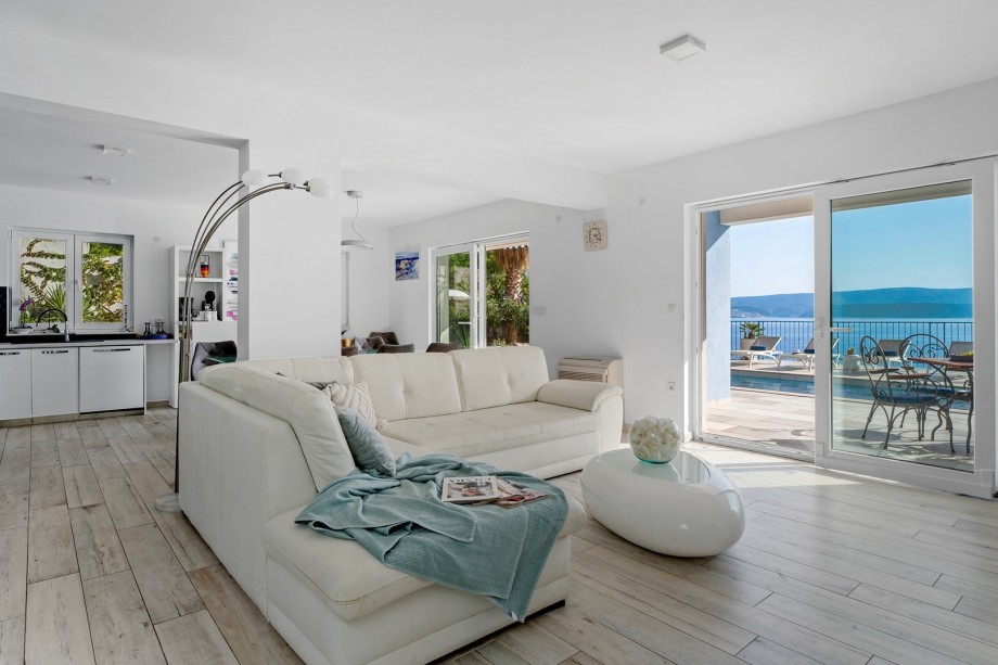 Modern furnished living area with exit to the pool.