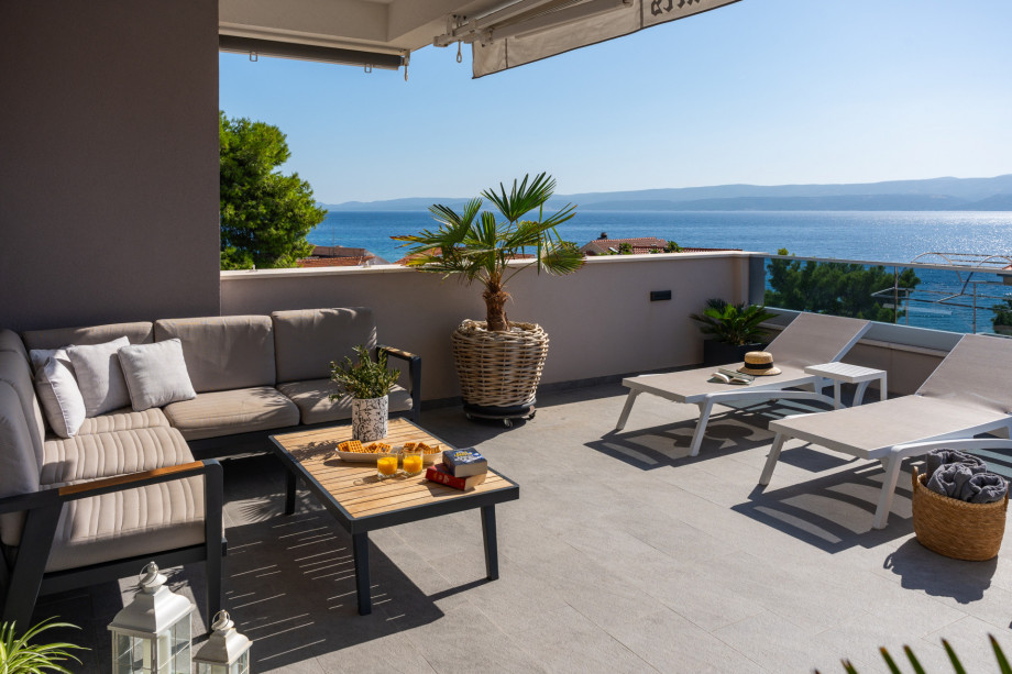 A terrace with lounge seating, 6 deck chairs, and a private swimming pool