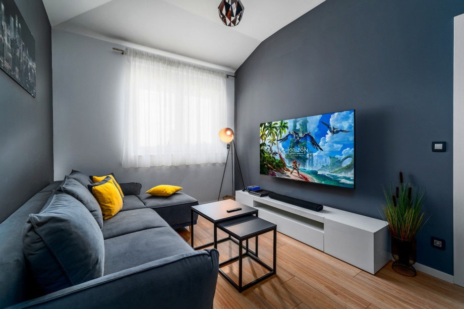 Large flat-screen television, Soundbar, PS4, and comfortable sofa