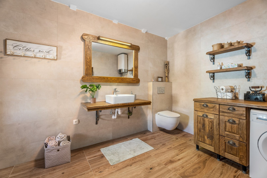 A separate family bathroom with a shower and a washing machine. There is also an iron with ironing amenities.