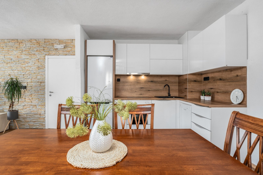 Dining table, living room with very comfortable sofa, a TV and a balcony with pool views