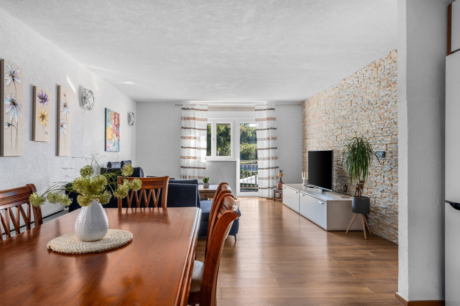 Dining table, living room with very comfortable sofa, a TV and a balcony with pool views