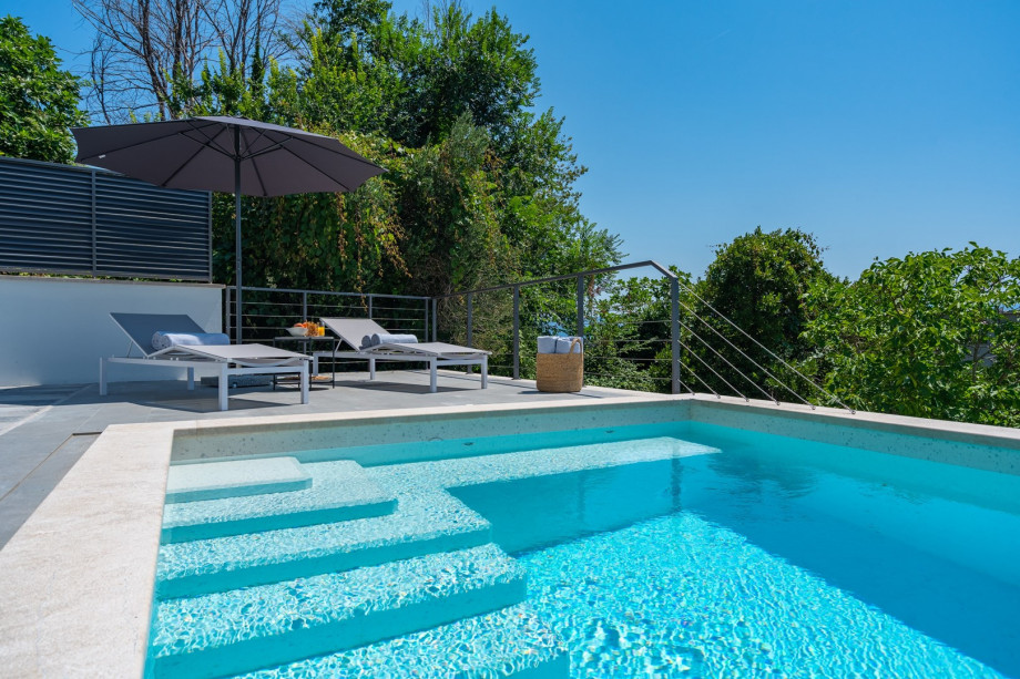 a sun deck area with 6 decks chairs overviewing town Omiš, sea and mountains