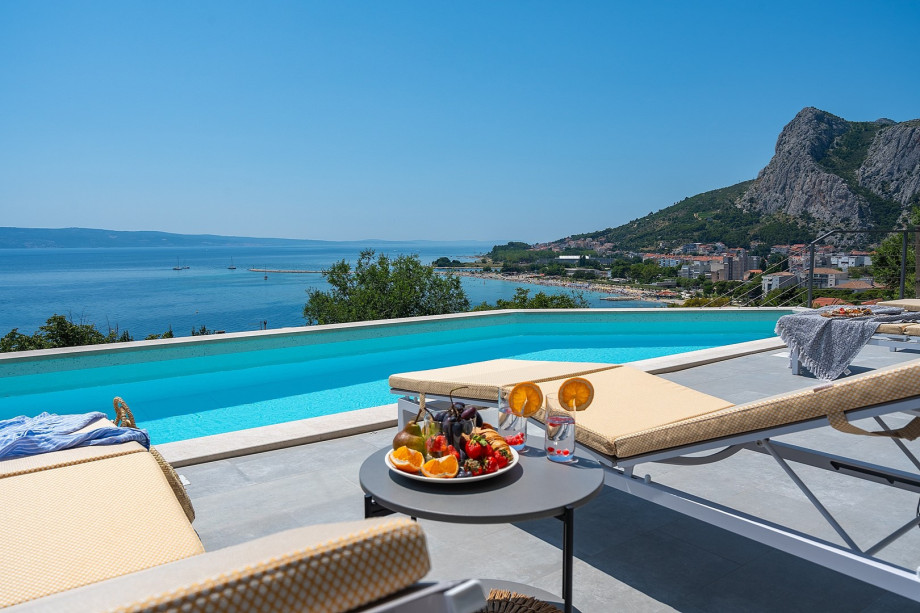 a sun deck area with 6 decks chairs overviewing town Omiš, sea and mountains