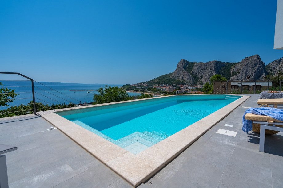 a sun deck area with 6 decks chairs overviewing town Omiš, sea and mountains