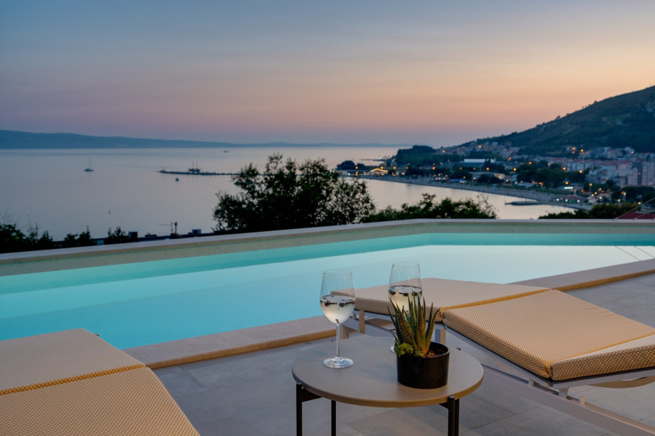 a sun deck area with 6 decks chairs overviewing town Omiš, sea and mountains