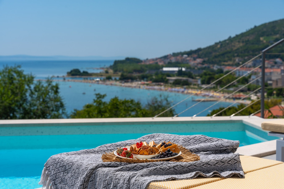 a sun deck area with 6 decks chairs overviewing town Omiš, sea and mountains