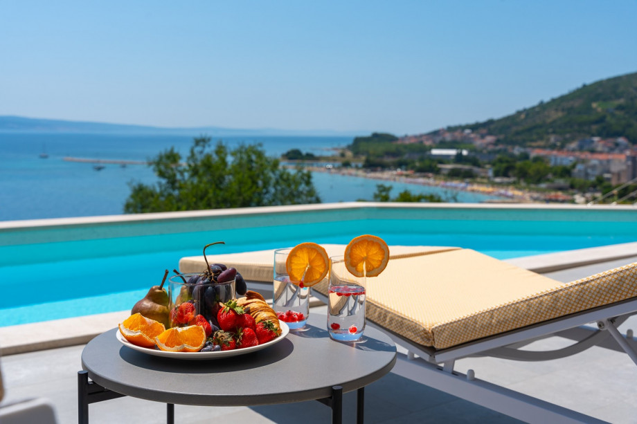 a sun deck area with 6 decks chairs overviewing town Omiš, sea and mountains