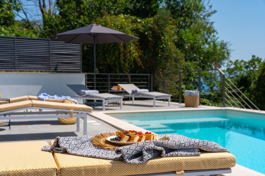 a sun deck area with 6 decks chairs overviewing town Omiš, sea and mountains