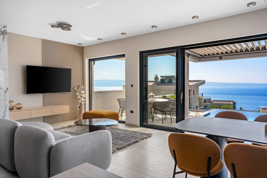 Living area with direct exit to covered outdoor dining area and pool