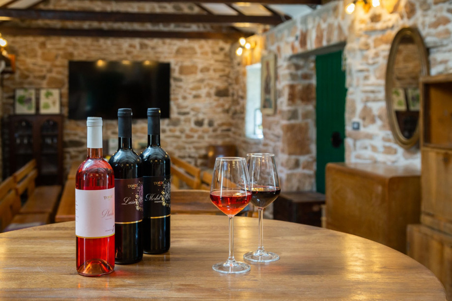 Summer kitchen with wooden dining tables and a flat screen TV, air conditioning and sofa chairs