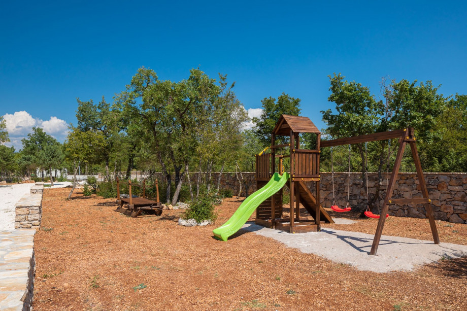 Children's playground with swings, a slide and small climbing frame