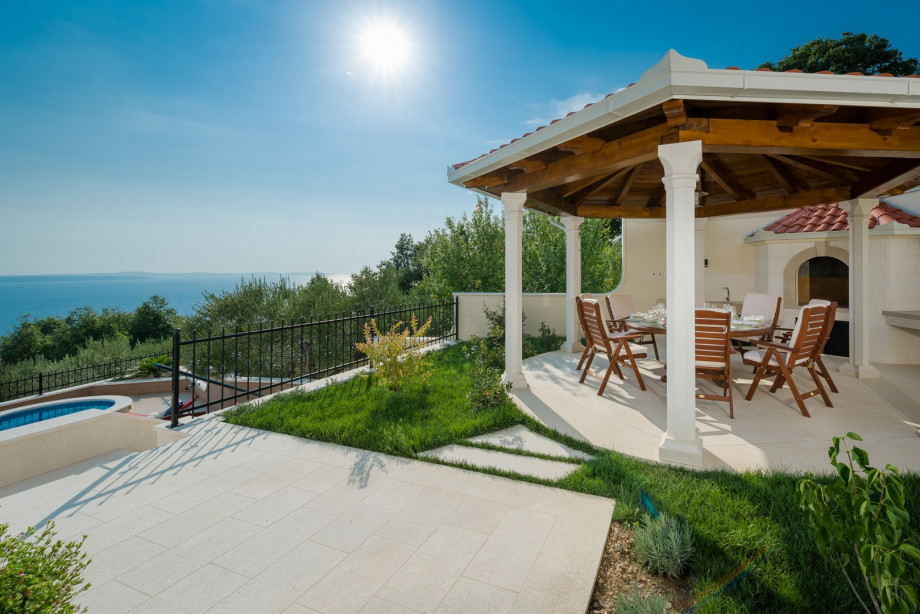 Outdoor dining area with barbecue all in living room and kitchen level (west)