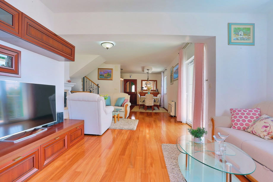 Living area (with exit to BBQ), TV, fireplace and dining area with kitchen