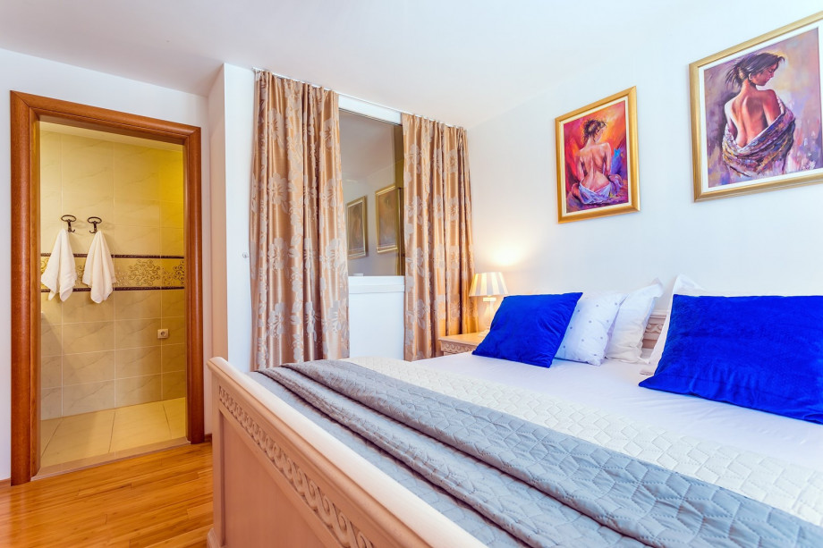 Bedroom No1. with double bed, TV, and en-suite bathroom with bathtub (pool level)