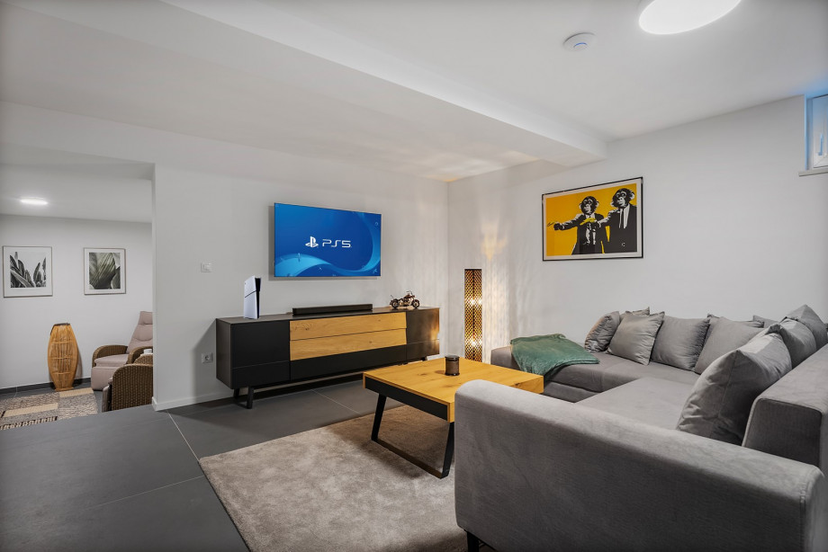 Media room with a sofa, PlayStation5, a TV and some games for more fun