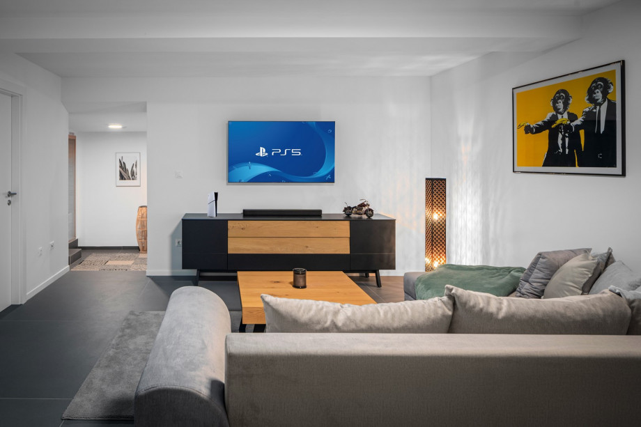 Staylis media room with a sofa, PlayStation5, a TV and some games for more fun