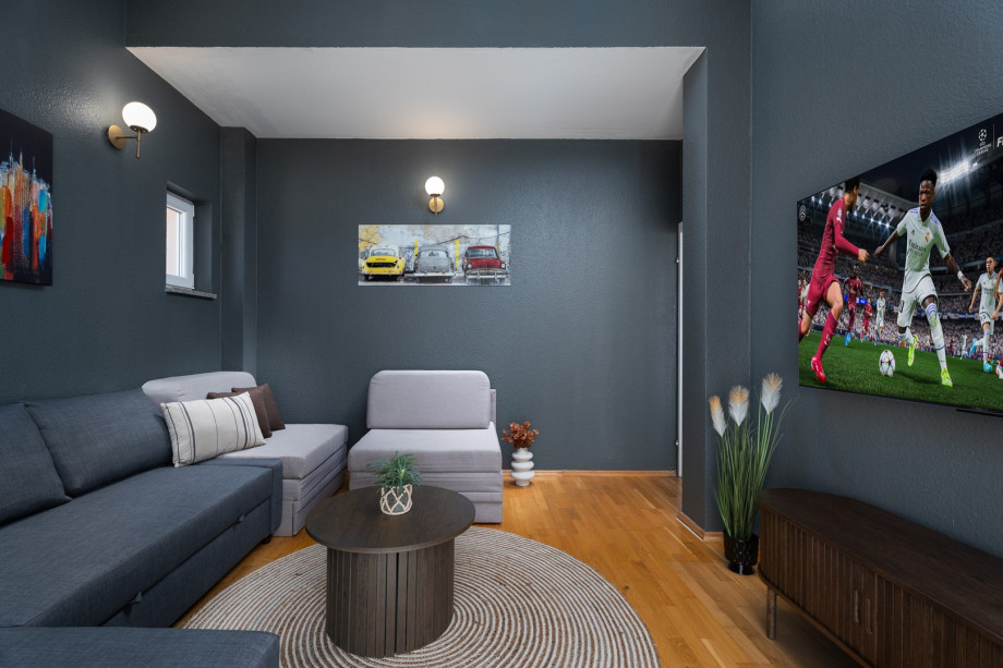 Media room with 3 sofa beds for four guests, and a big TV with PlayStation5