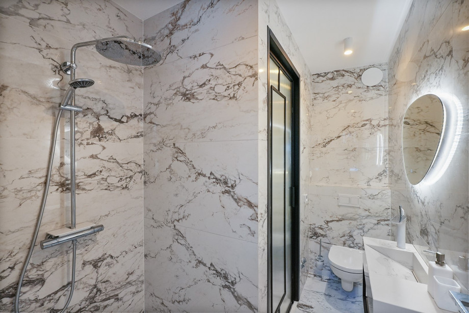 An en-suite bathroom with a shower, a sink, and a toilet