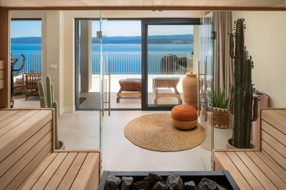 The glass doors also lead to a terrace that has an outdoor shower, two deck chairs, and a lounge area