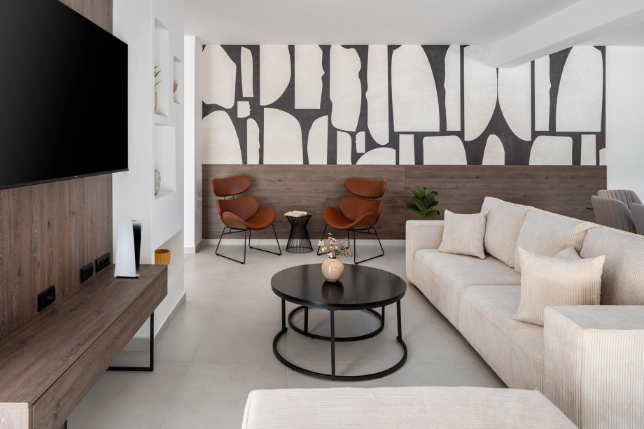 living room complete with comfy sofas, a smart TV, and a PlayStation 5