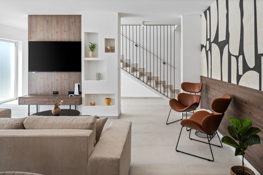 living room complete with comfy sofas, a smart TV, and a PlayStation 5