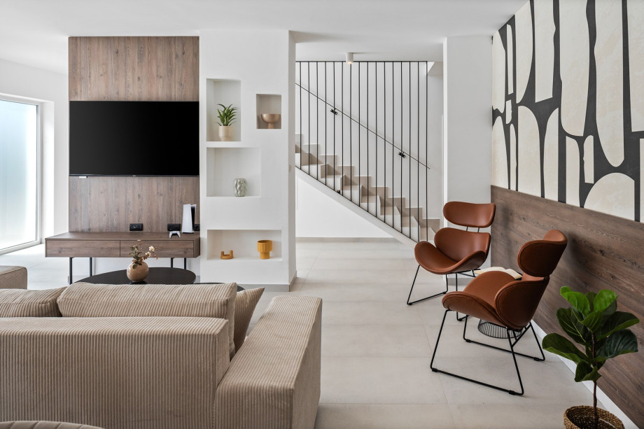 living room complete with comfy sofas, a smart TV, and a PlayStation 5