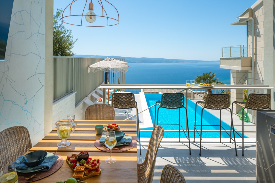 There is a summer kitchen (21sqm) with a barbecue, covered dining space with a TV and 4 bar chairs