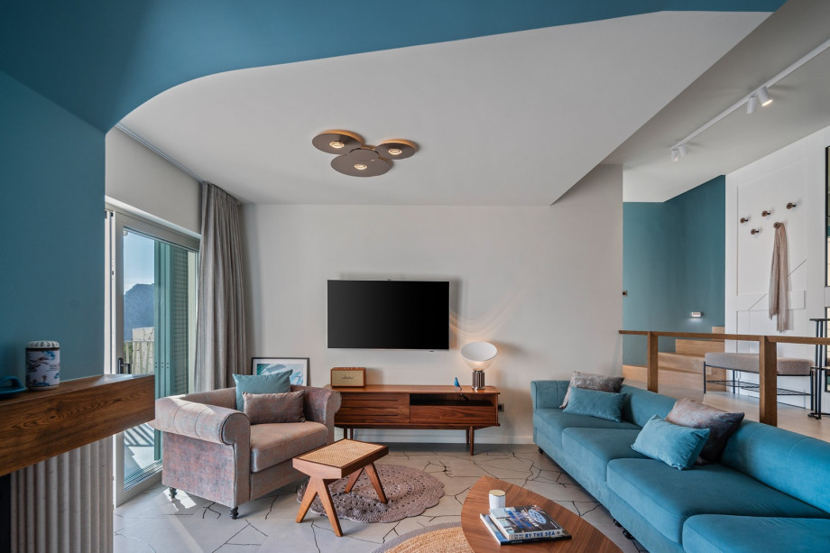 It features a chic living and dining space that opens up to the pool and lounge area through glass doors