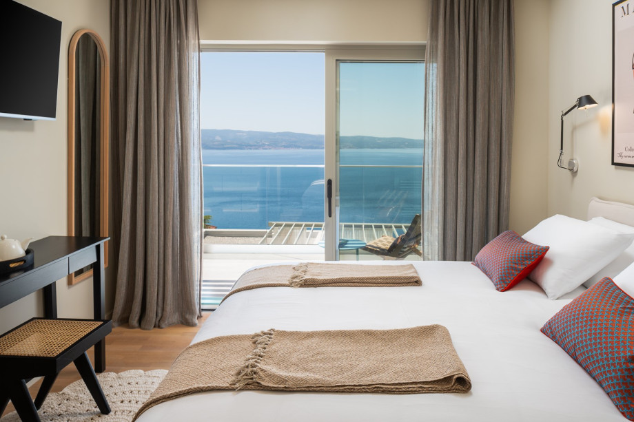 Air conditioning, a TV, and a balcony offering panoramic sea views that is shared with Bedroom 2