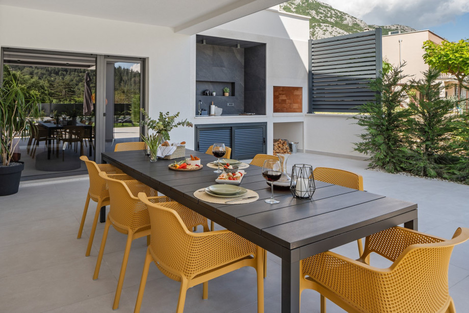 a covered dining area with a barbecue (wood and charcoal)