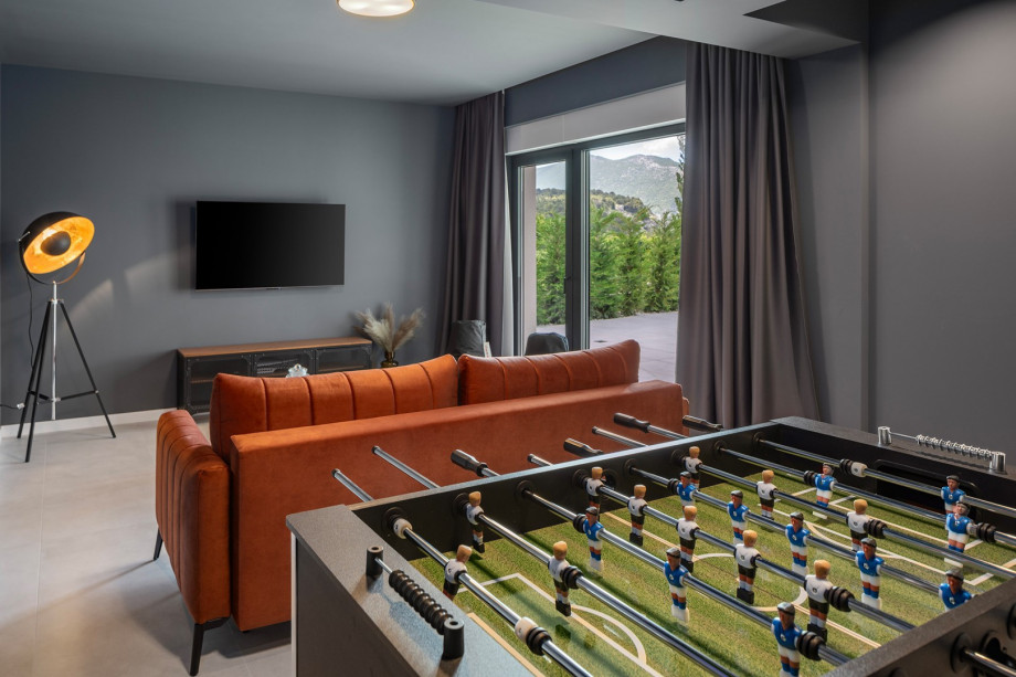 Media room with TV, PlayStation 5, AC, couch and foosball table