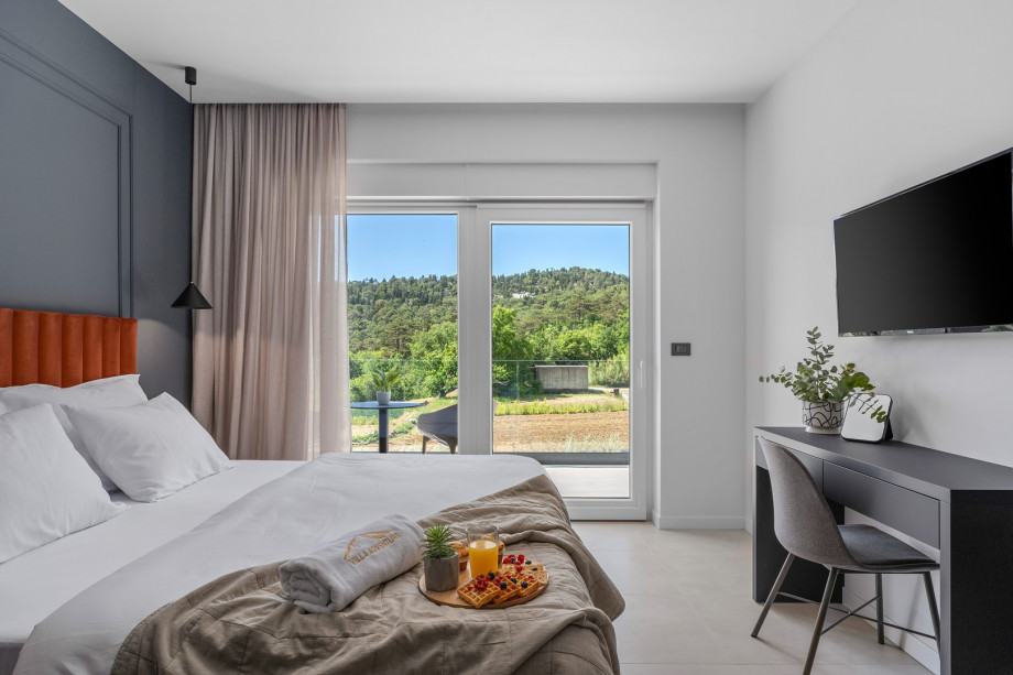 Bedroom NO2 with a king-size bed, A/C, TV, balcony overlooking the pool and surrounding landscape, and ensuite bathroom with a shower.