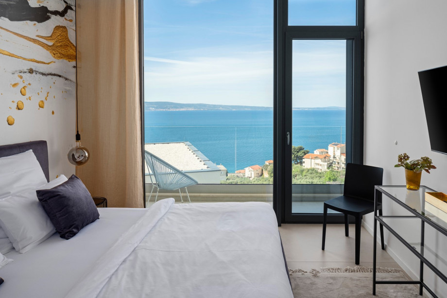 Bedroom NO2 with king-size bed and a balcony with views of the pool and sea
