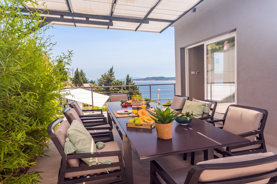 There is a covered outdoor dining area with barbecue and direct entrance to the kitchen