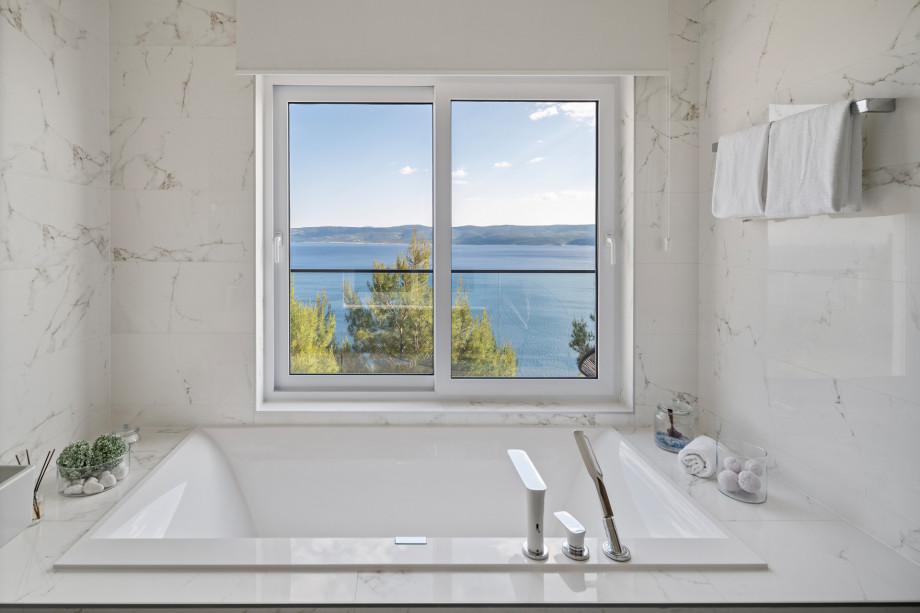 En-suite bathroom No.1 with a shower and a bathtub with sea views