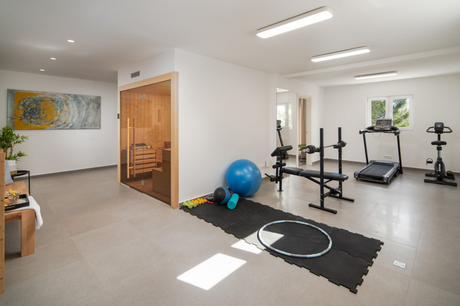 Sauna and gym with a Treadmill, exercise bike, and a bench, the lowest floor