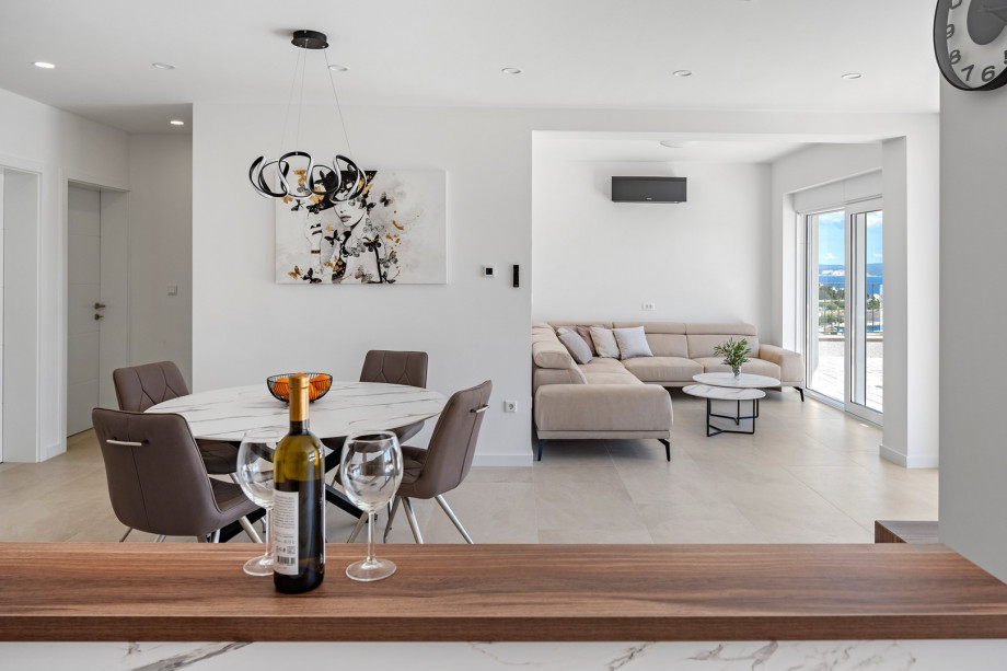 Ground foor with open concept living area and glass doors toward the pool