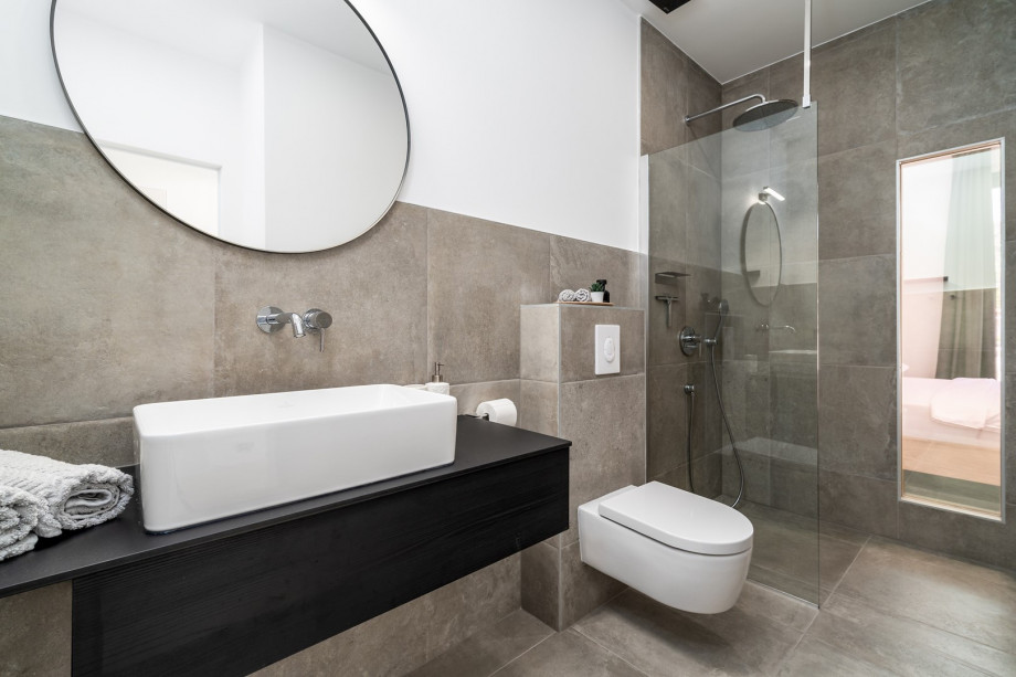 en-suite bathroom with a shower. There is also a laundry with a washing machine and a ironing amenities