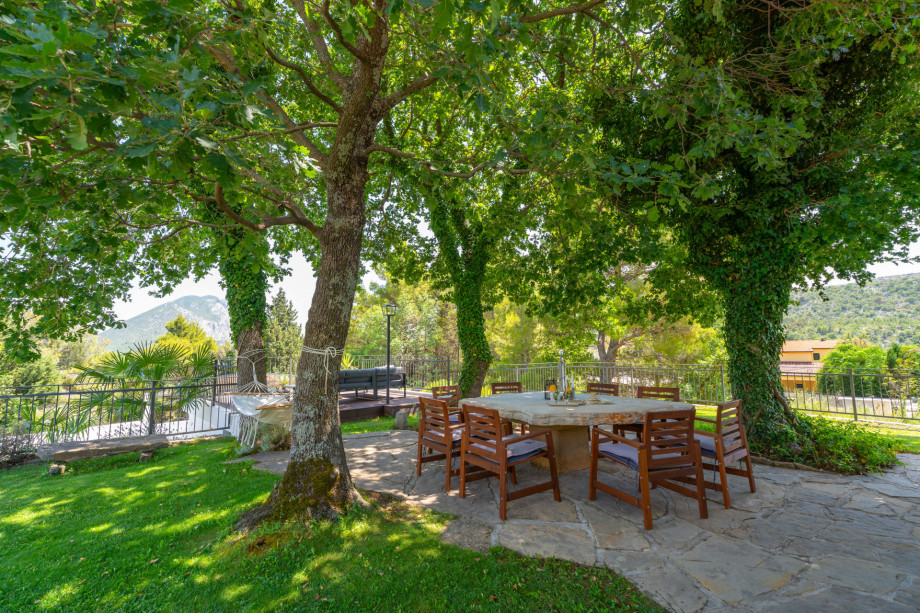 Natural shade by old oak trees, and unique stone table for 8 people