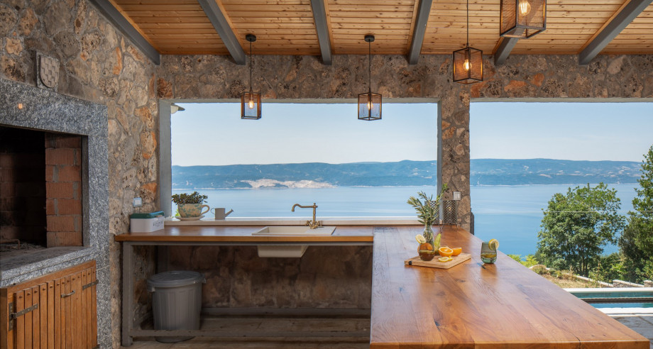 Kitchen island with stools overlooking the pool, the natural surroundings, island Brac and the sea