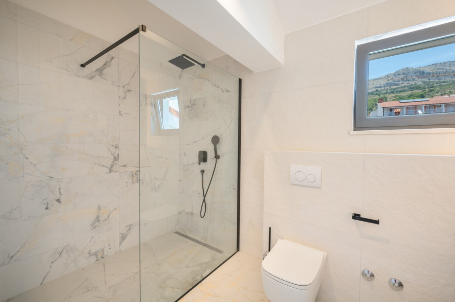 An en-suite bathroom with a shower, a sink, and a toilet