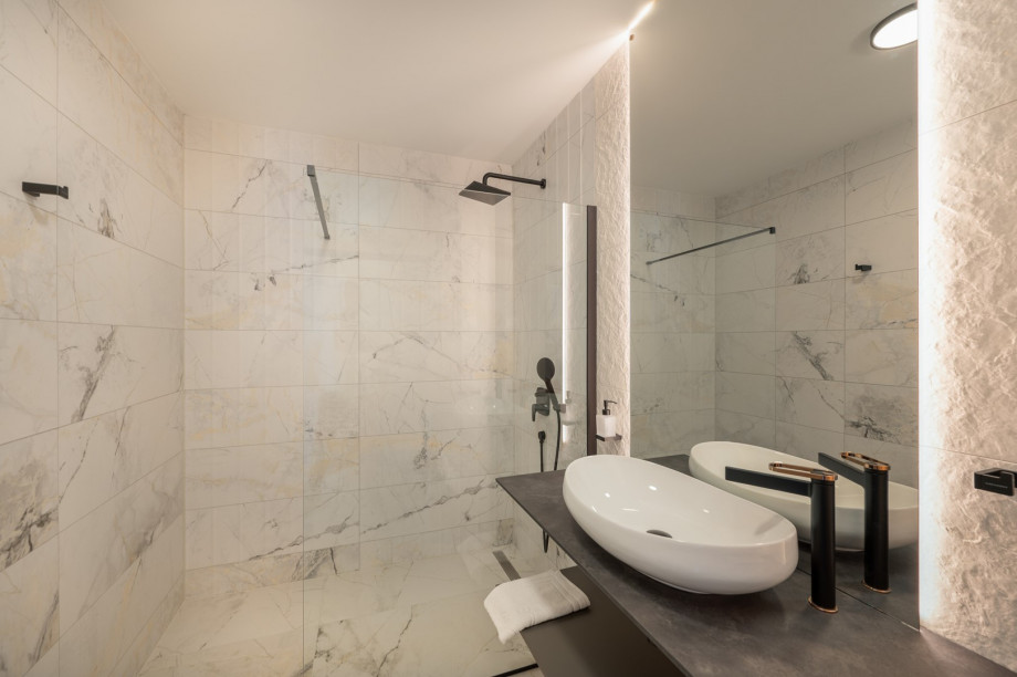 An en-suite bathroom with a shower, a sink, and a toilet