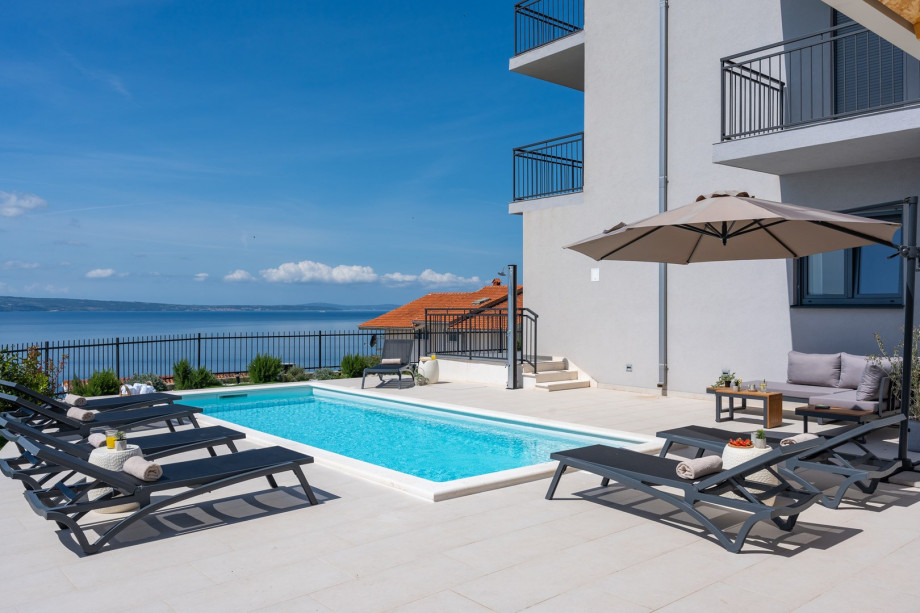 Spacious sun deck area with 10 deck chairs, sun umbrellas and a lounge corner