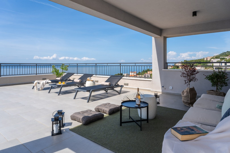 This residence boasts five spacious bedrooms, two fully equipped kitchens, and two inviting living rooms