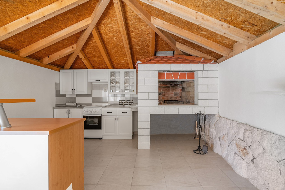 Fully equipped summer kitchen with barbecue and covered area for dining and sitting