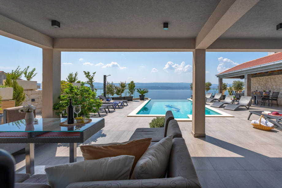 Outdoor lounge corner with amazing pool and sea view