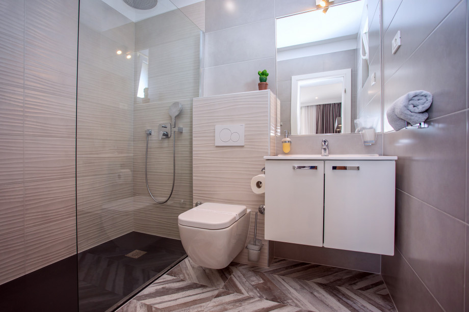 An en-suite bathroom with a shower, a sink, and a toilet connected to bedroom No.5