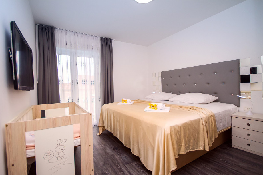 Bedroom No.2 with 200x200 bed, baby cot, lcd tv, air conditioning and balcony