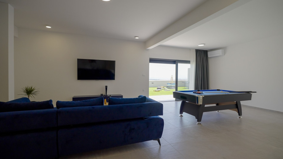 A/C FUN zone with a sofa (can convert into sofa bed), a flat screen TV, a PlayStation 5, a Billiards (Pool table), a Table tennis, and a separate toilet.